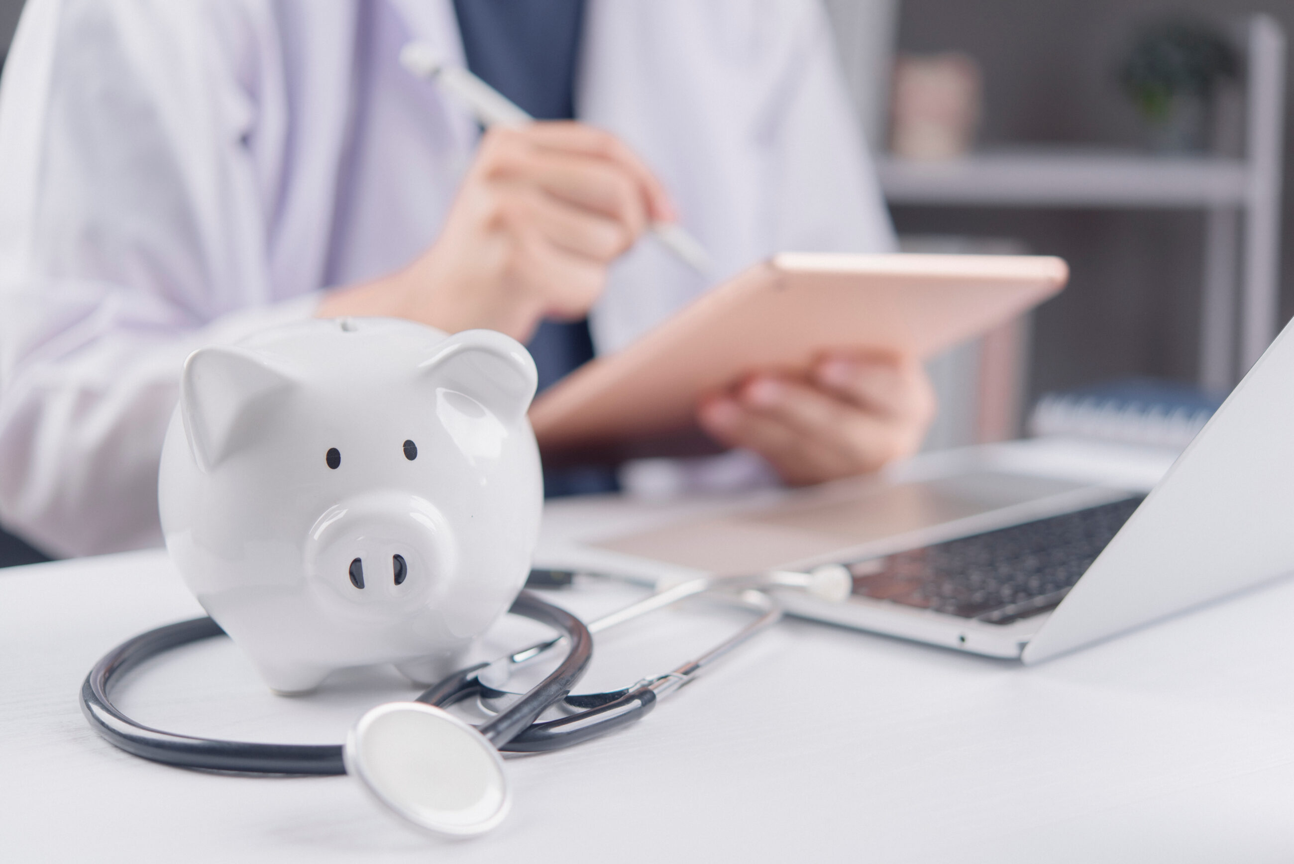 Healthcare professional planning asset protection and financial independence, with piggy bank and stethoscope symbolizing wealth protection and liability management.