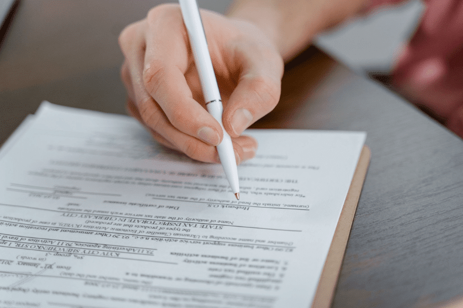 Hand signing a formal business document with a pen