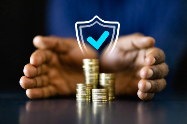 A shield protecting and covering some coins.