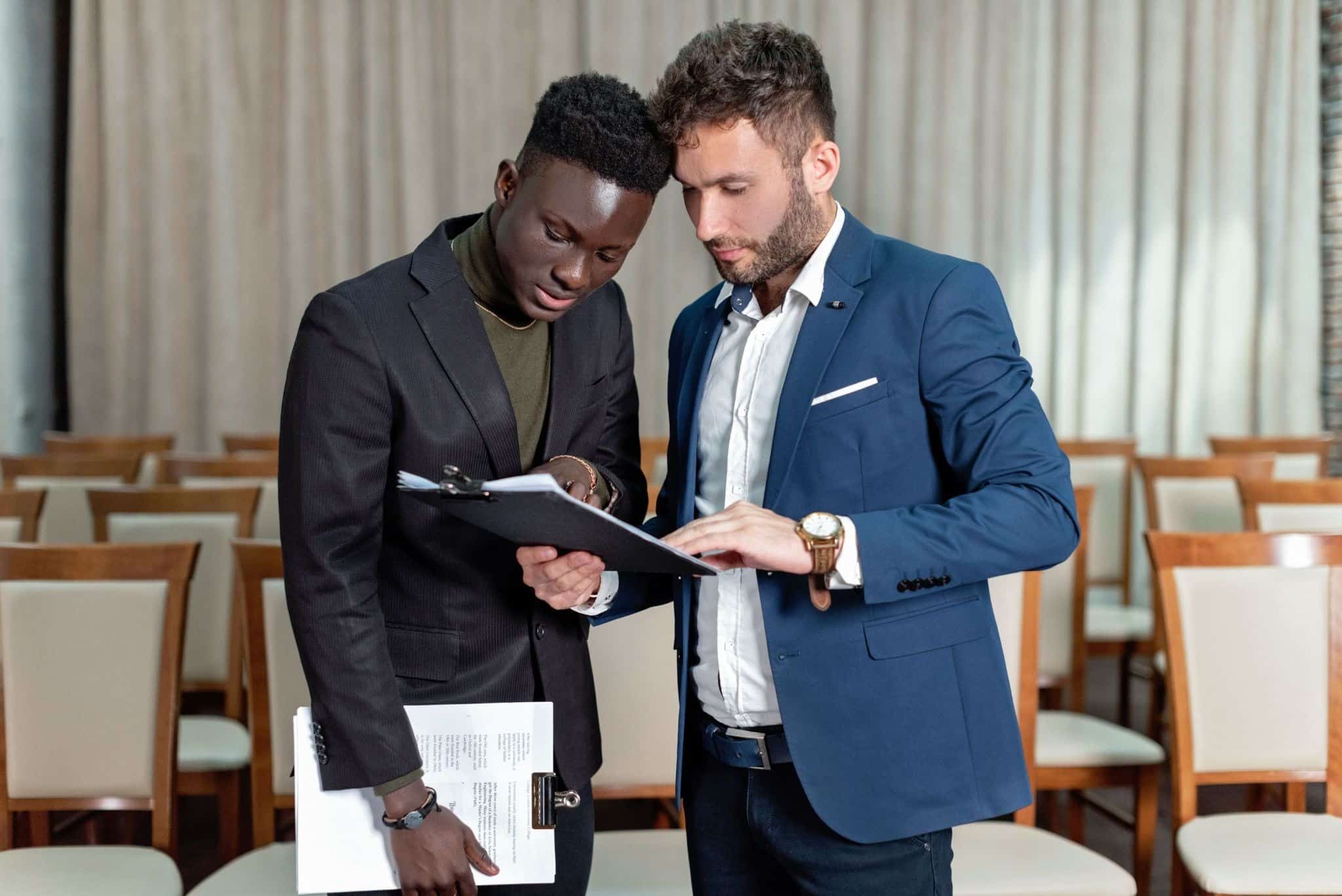 Two business partners reviewing a document together, representing a buy-sell agreement discussion