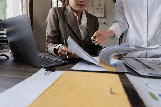 A lawyer and medical professional review tax documents.