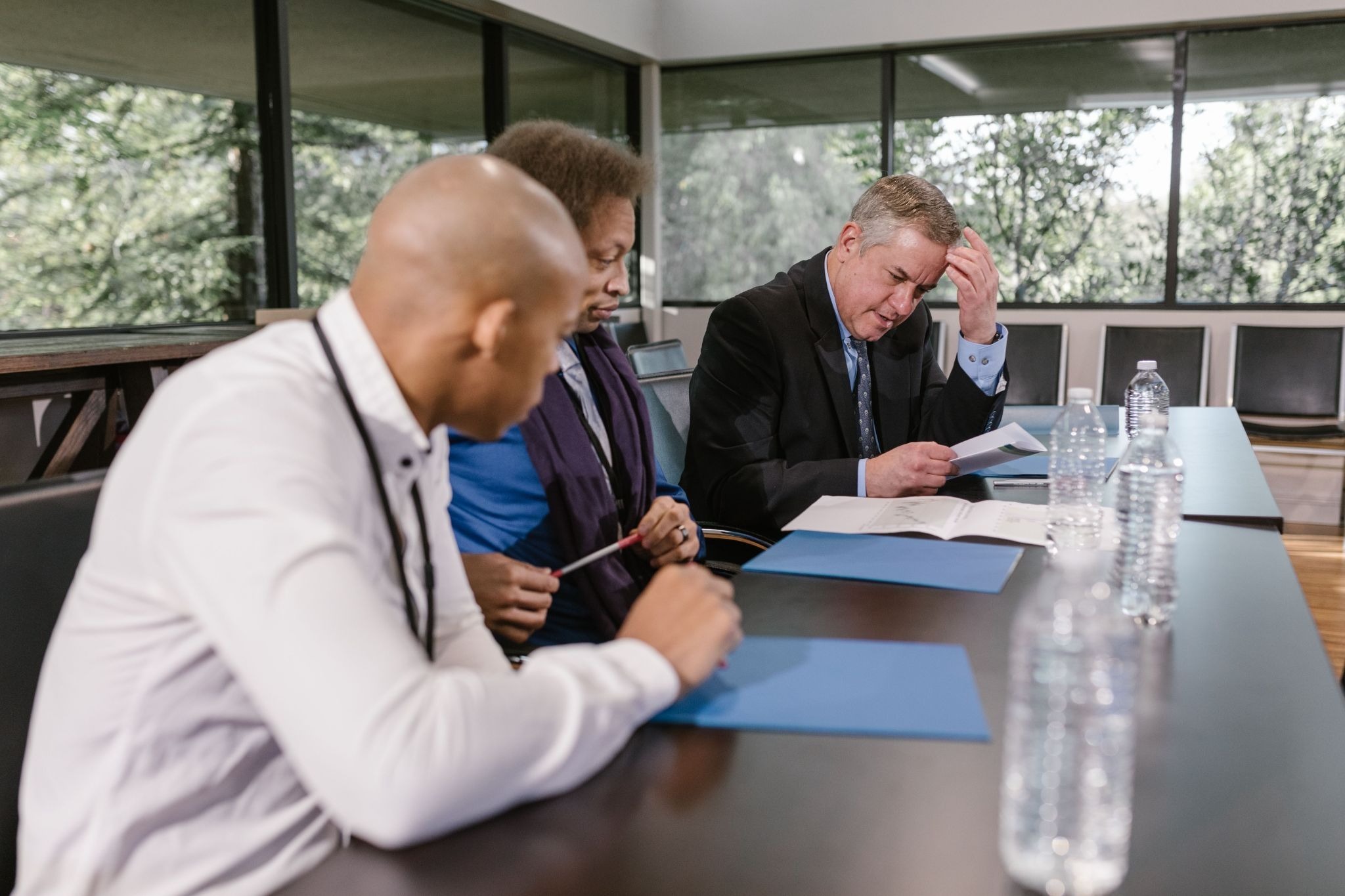 A formal business meeting between medical professionals discussing a protective partner lawsuit practice structure with advisors 