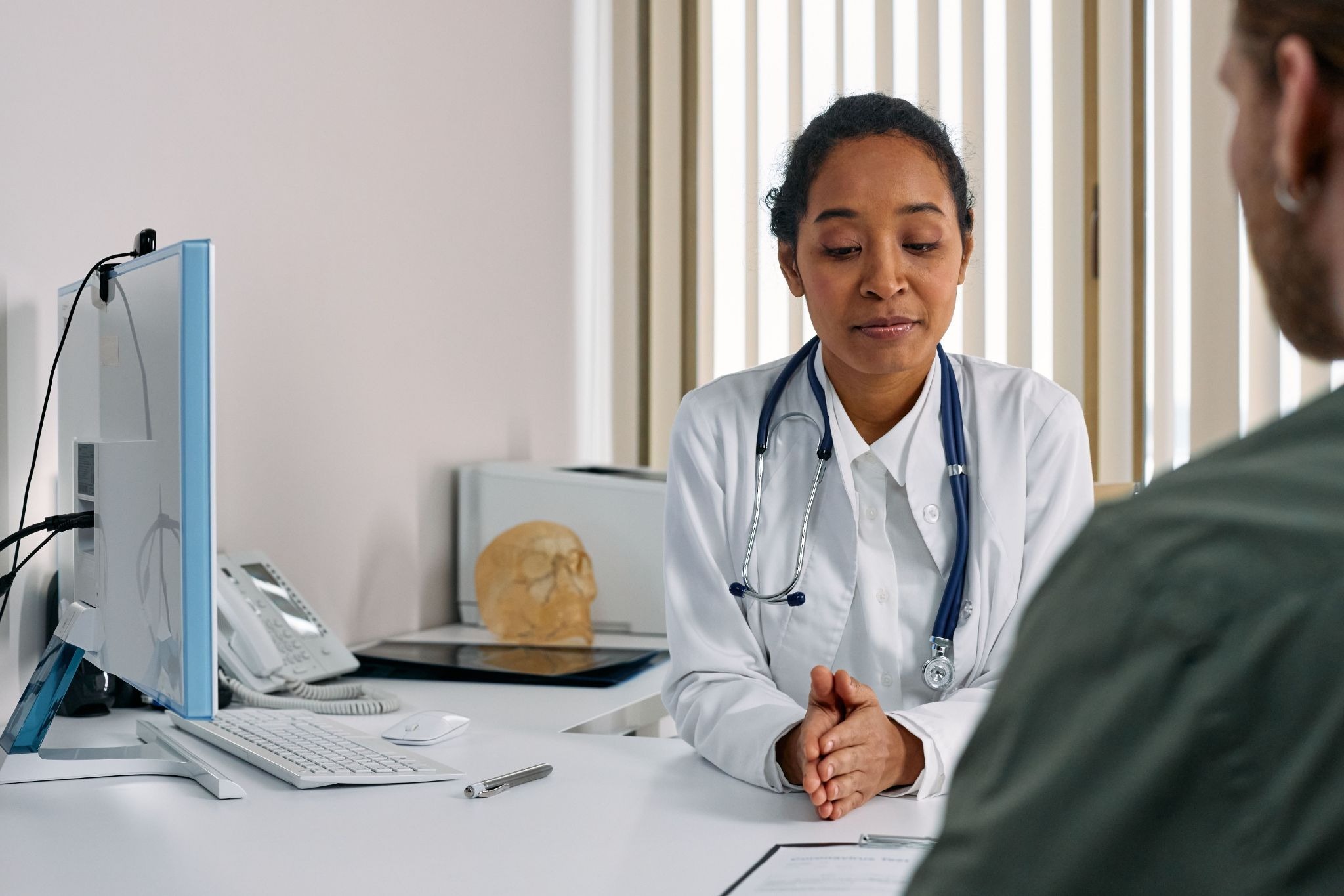 Doctor explaining medical malpractice lawsuit triggers to staff.