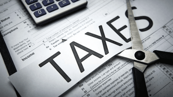 Visual representation of literally cutting taxes, but meaning it figuratively.