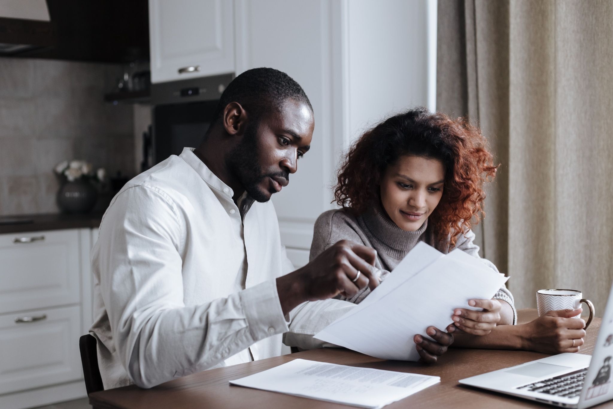 Physician and spouse going over home equity documents at a kitchen table