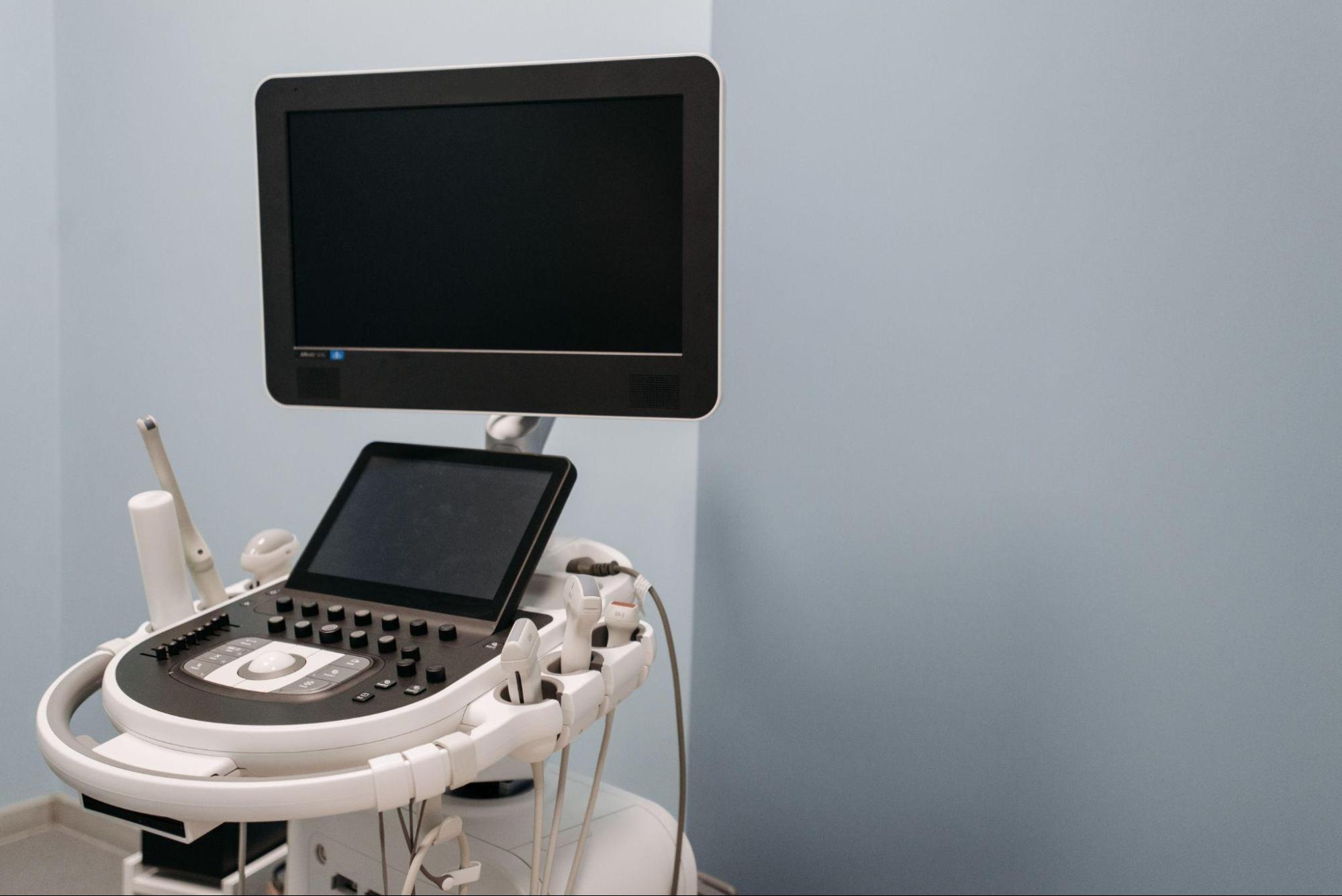 Ultrasound machine set up and operating in a clinic exam room, showing equipment that has been placed in service.
